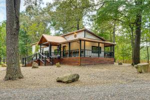 a small house in the middle of a forest at Hike, Fish and Unwind Cabin with Yard in Broken Bow! in Broken Bow