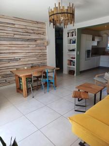 a living room with a wooden table and chairs at Appartement en rez de jardin 4 personnes in Carqueiranne +3 photos