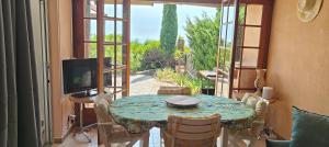 a dining room with a table and a television at Bella Vista Colline Valmer in La Croix-Valmer