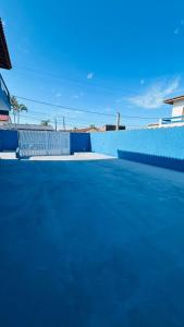 una piscina azul con una valla azul en Pousada Mar e Sol, en Peruíbe 17 fotos más