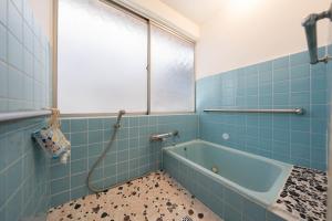 a blue tiled bathroom with a bath tub at Former Yoshidaya Hikonana Residence, a Registered Tangible Cultural Property 倉敷の宿 国登録有形文化財 旧吉田彦七邸 一棟貸切 1日1組限定 特別な体験 日本の伝統建築で過ごす非日常を in Kurashiki +37 photos