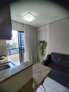 een woonkamer met een bank en een tafel bij Studio Urbano Sun Square hotel in Goiânia