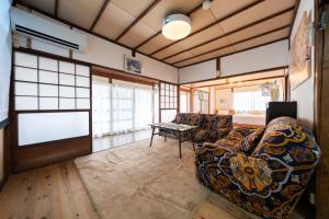 a living room with a couch and a table at Former Yoshidaya Hikonana Residence, a Registered Tangible Cultural Property 倉敷の宿 国登録有形文化財 旧吉田彦七邸 一棟貸切 1日1組限定 特別な体験 日本の伝統建築で過ごす非日常を in Kurashiki