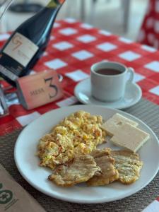 a plate of food and a cup of coffee on a table at Hotel De La Prada in Maicao