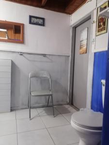 a chair in a bathroom with a toilet at Cabaña la Estancia en la Isla in Isla Negra +12 photos