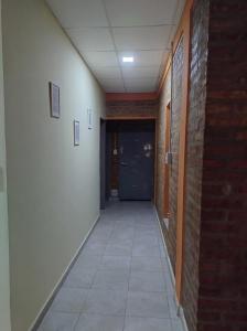 an empty hallway with a door and a tile floor at Departamento Saturnino in Neuquén