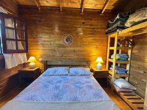 ラ・ファルダにあるCabaña turistica para huespedes!のベッドルーム1室(ベッド1台、二段ベッド1組付)