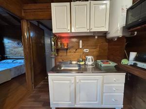 ラ・ファルダにあるCabaña turistica para huespedes!の白いキャビネットとシンク付きのキッチンが備わります。
