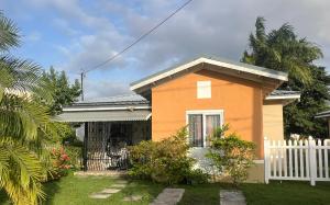 a small house with a white fence in a yard at The Relax Suite Montego Bay in Montego Bay