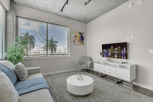 a white living room with a couch and a tv at Tropicana Stadium 2 Bed In DWTWN With Free Parking in St Petersburg