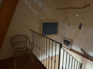 a staircase with a chair and a painting on the wall at Da Luisa al Castello in Montemaggiore al Metauro