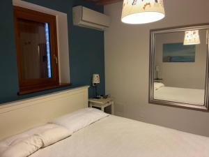 a bedroom with a white bed and a mirror at Da Luisa al Castello in Montemaggiore al Metauro +25 photos