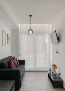 a living room with a couch and a large window at Luxury Apartment Narama zona 13 Aurora Airport #555 in Estación Pamplona
