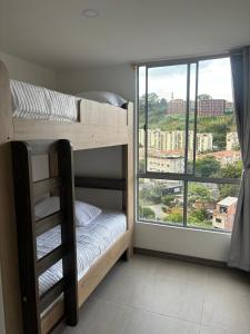 a bedroom with bunk beds with a large window at Apartamento en Guayabal - Medellín in Estación El Salto