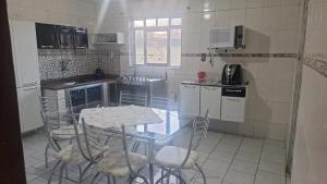 a small kitchen with a table and chairs in it at Casa da Marlene in Resende