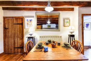 a dining room with a wooden table and chairs at Mundles Cottage in Whittingham +4 photos
