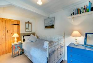a bedroom with a bed and two lamps and a dresser at Mundles Cottage in Whittingham