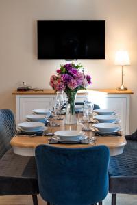 una mesa larga con platos y un jarrón de flores en Old Farm, en Warenford