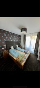 a bedroom with two beds and a wall with birds on it at Happy Seasons Szoboszló in Hajdúszoboszló