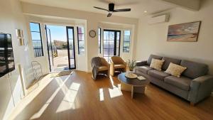 a living room with a couch and a table at Cielo Flaxton, Newly Renovated Luxury Accommodation with Ocean and Iconic Views in Flaxton