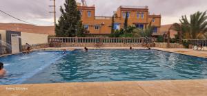 a group of people swimming in a swimming pool at Bio Palace Hotel in Tinerhir