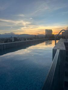 Una piscina en lo alto de un edificio con una puesta de sol. en Apartment in North Rome, en Ciudad de México