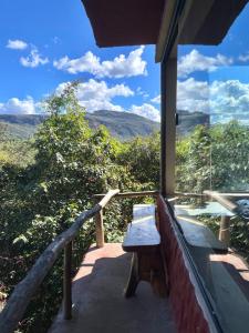 a bench sitting on a porch with a view at Loft Urucum in Palmeiras +10 photos