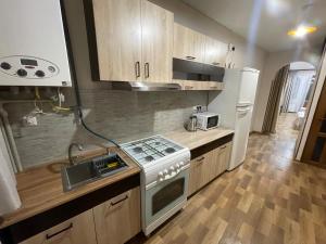 a small kitchen with a stove and a refrigerator at Уютный дом in Yerevan +4 photos