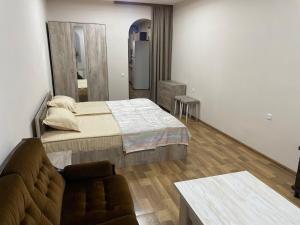 a bedroom with a bed and a couch in a room at Уютный дом in Yerevan