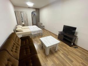 a living room with a couch and a flat screen tv at Уютный дом in Yerevan