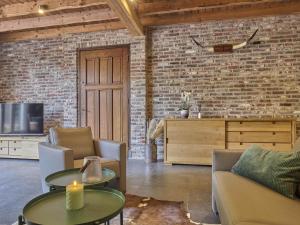a living room with a couch and tables and a tv at De Rouwenbogt in Hulsel