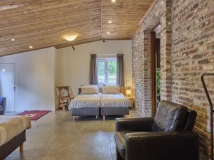 a bedroom with two beds and a brick wall at De Rouwenbogt in Hulsel