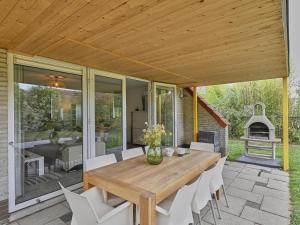 a wooden table and chairs on a patio at Villa Christina in Stevensweert