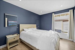 a blue bedroom with a bed and a window at 3BR The Lucille Lake Washington View Retreat in Seattle