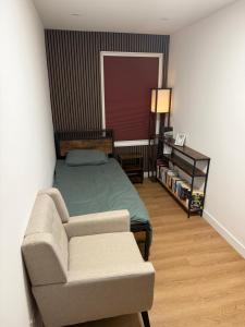 a bedroom with a bed and a couch and a chair at Modern East London Apartment with Private Studio & Guest Rooms-Near Bow, Victoria Park in London +60 photos