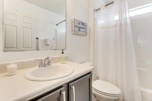 Un baño blanco con lavabo e inodoro. en 11 Mi to Beach Quiet Gulf Breeze Gem Near Dtwn, en Gulf Breeze 18 fotos más