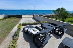 a patio with a table and chairs and the ocean at Seaside house for families with children Banj, Pasman - 24665 in Kukljica