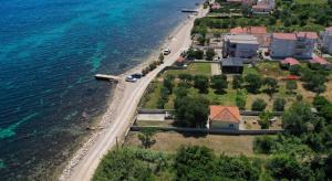 an aerial view of a house next to the ocean at Seaside house for families with children Banj, Pasman - 24665 in Kukljica +16 photos