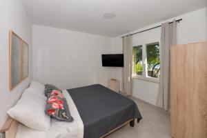 a bedroom with a bed and a large window at Seaside house for families with children Banj, Pasman - 24665 in Kukljica