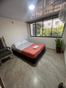 a bedroom with a bed and a chair in it at Casa Crespo Caribe Cartagena in Cartagena de Indias