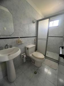 a white bathroom with a toilet and a sink at Casa Crespo Caribe Cartagena in Cartagena de Indias