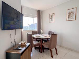 a dining room with a table and chairs and a television at 303-AP Próx Unipam e Parq expo-AR-Elevador-Garagem in Patos de Minas