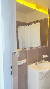 une salle de bains avec un lavabo et un miroir dans l'établissement Los Soles de Madryn, à Puerto Madryn