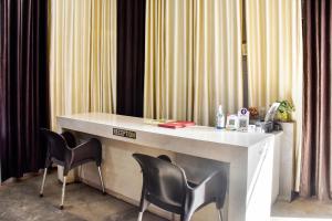 JāmulSPOT ON City Tower Inn的窗帘间配有一张桌子和两把椅子