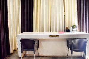 JāmulSPOT ON City Tower Inn的一张桌子，两把椅子，上面挂着一个登记牌。