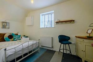 una camera da letto con un letto e una sedia blu di Pinnacle Cottage a Heacham
