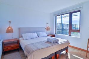 a bedroom with a bed and a large window at HOM I Depto familiar a pasos del lago in Puerto Varas