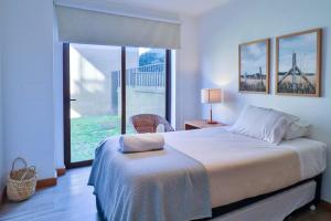 a bedroom with a large bed and a large window at HOM I Depto familiar a pasos del lago in Puerto Varas