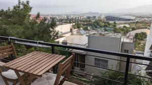 a wooden table and chairs on a balcony with a view at Acropolis View Condo, perfect location! in Piraeus