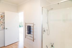 a bathroom with a shower with a glass door at Reel retreat - sunny with views! in Waihi Beach +31 photos